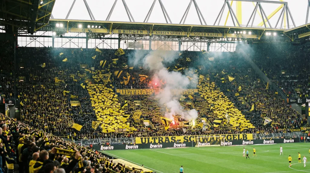 Grada sur del Signal Iduna Park repleta de aficionados con banderas amarillas y negras durante un partido de Bundesliga